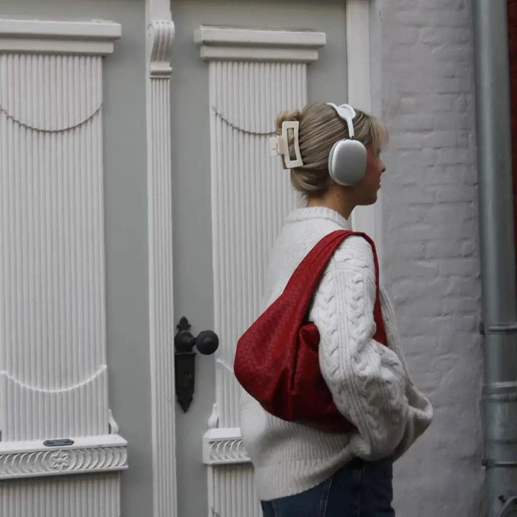 Coole Frau in Berlin mit einer roten Handtasche und einer cremeweißen Haarspange im Haar