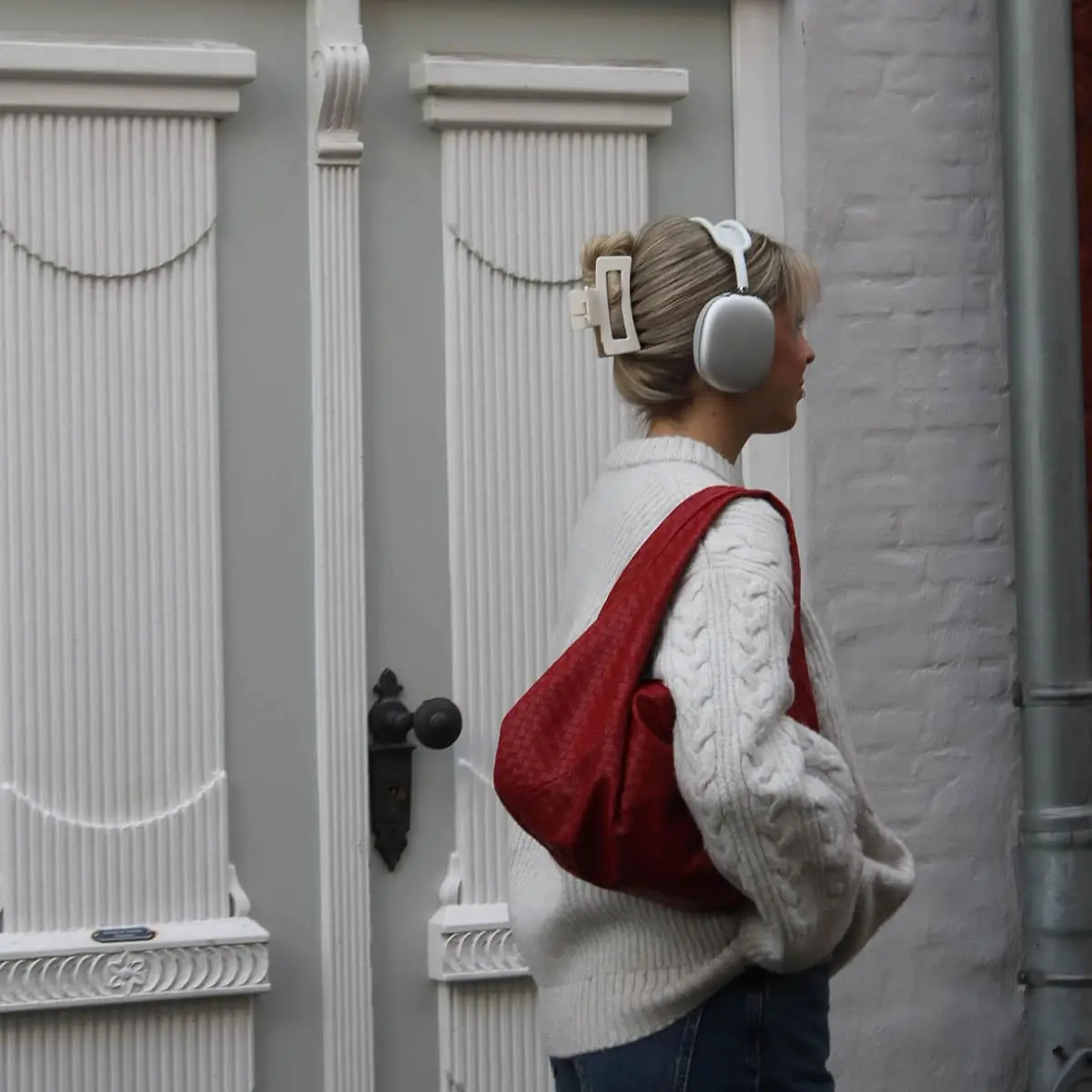 Coole Frau in Berlin mit einer roten Handtasche und einer cremeweißen Haarspange im Haar